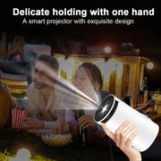 HY300 Android Portable Projector held outdoors, projecting image during movie night, showcasing easy one-hand operation.